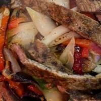 Sizzling Fajitas · All sautēed with green and red bell peppers, garlic and onions. Served with rice and black b...