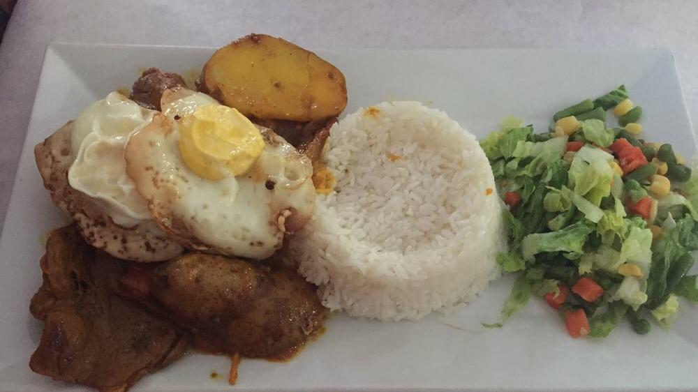 Bistec Encebollado · Top round steak with onions and with two side orders.
