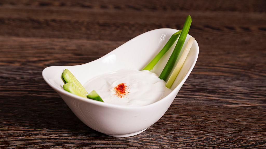 Suzma · Thick lightly salted yogurt with cucumber sticks.