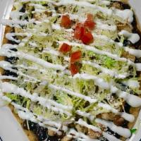 Huarache · Homemade thick tortilla topped with beans, cream, cheese, and lettuce. / Aderezado con frijo...