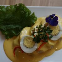 Papa À La Huancaína · Sliced baked potato topped with our homemade creamy yellow sauce.
