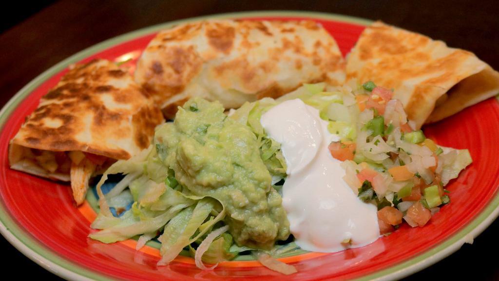Quesadilla Rellena · A grilled flour tortilla with a choice of chicken or ground beef, melted cheese served with guacamole salad and beans.