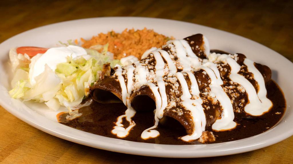 Mole Ranchero · Grilled chicken with mole sauce served with tortillas, rice and beans.