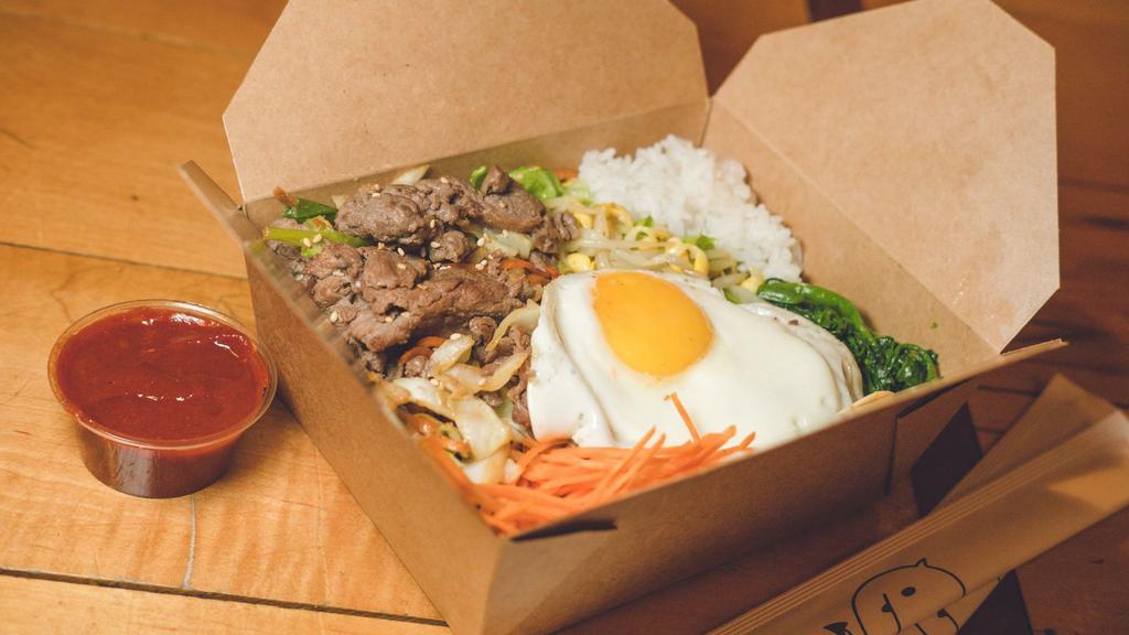 Bulgogi Bibimbap · Traditional Korean rice bowl with lightly seasoned and sautéed vegetables and bulgogi, topped with a sunny egg. Served with gochujang (sweet and spicy chili pepper paste) and an assortment of traditional side dishes (banchan). *Cannot be made gluten free