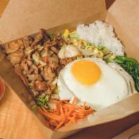 Pork Bibimbap · Traditional Korean rice bowl with lightly seasoned and sautéed vegetables and pork, topped w...
