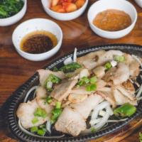 Samgyeopsal · Sliced un-marinated pork belly sautéed with onions, garlic and Korean peppers. Served with f...