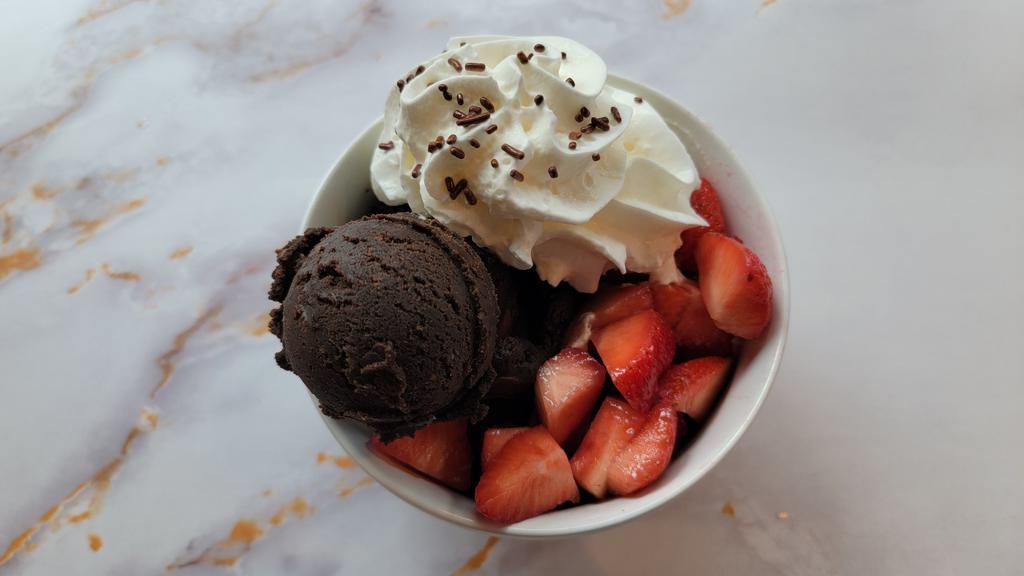 The Kiss Dough · Edible Triple Chocolate Cookie Dough with Hershey Kisses Topped with Fresh Strawberries, Whipped Cream and Chocolate Sprinkles.