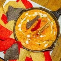 Buffalo Chicken Dip · Braised chicken, blue cheese, and hot sauce, topped with ranch dressing and served with corn...