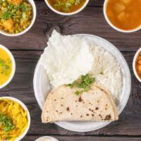 South Indian Thali · 3 curry, sambar, rasam, dal, papad, pickle, dessert & rice with poori or chapati .
