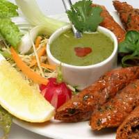 Lamb Sheek Kabab · Minced lamb rolls flavored with medium spices, served piping hot on sizzler with onion and l...