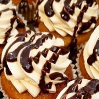 Banana Peanut Buttah Cupcake · Banana cupcake frosted with peanut butter Swiss buttercream topped with dark chocolate ganac...