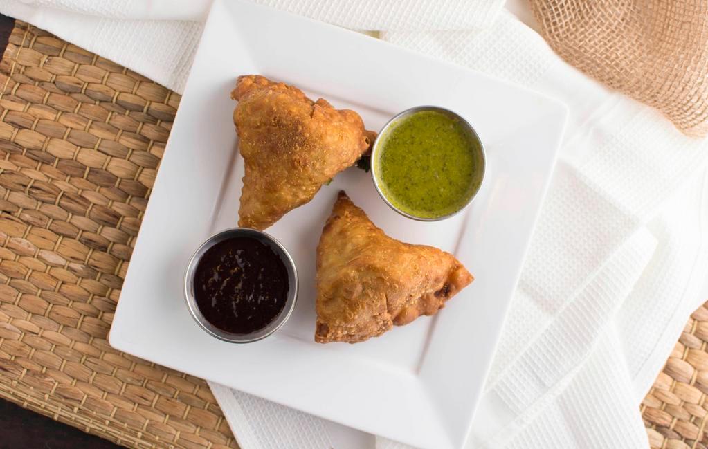Vegetable Samosa · Crispy fried turnover deliciously filled with mildly spiced potatoes and green peas.