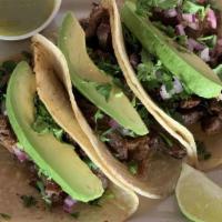 Tacos Skirt Steak · Three tacos served with skirt steak, onions and cilantro.