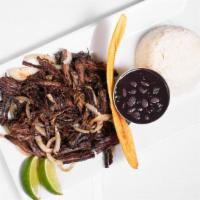 Vaca Frita · Pan-fried shredded skirt steak flavored with mojo criollo sauce. Served with black beans and...