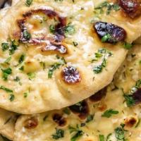 Garlic Naan · Unleavened bread with lots of garlic and fresh cilantro baked in a clay oven.