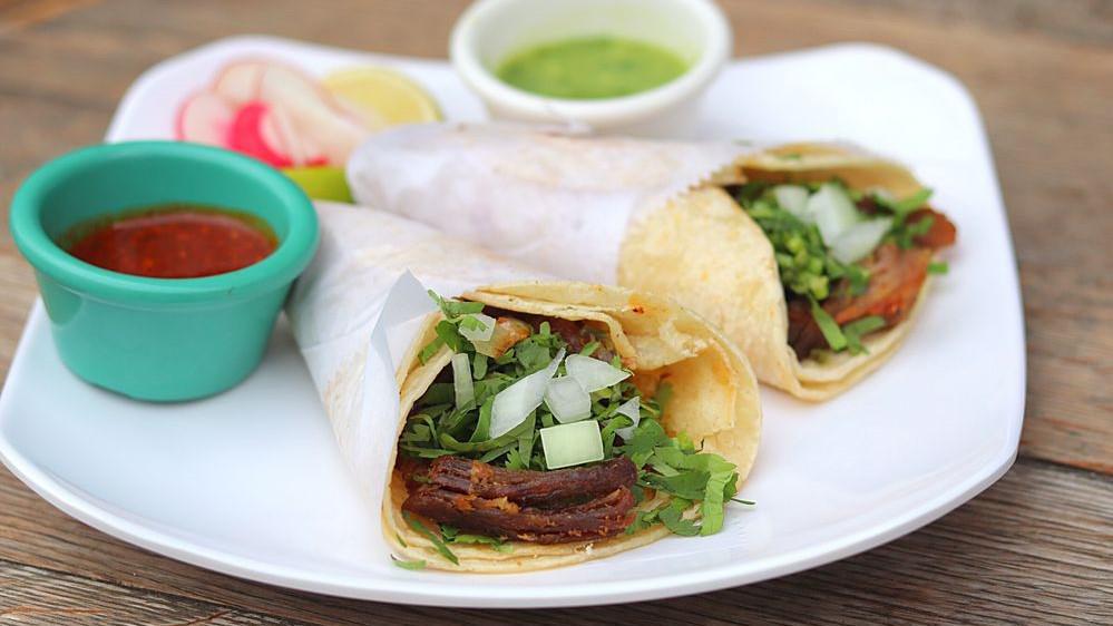 Lengua · Beef tongue. Served with onions and chopped cilantro.