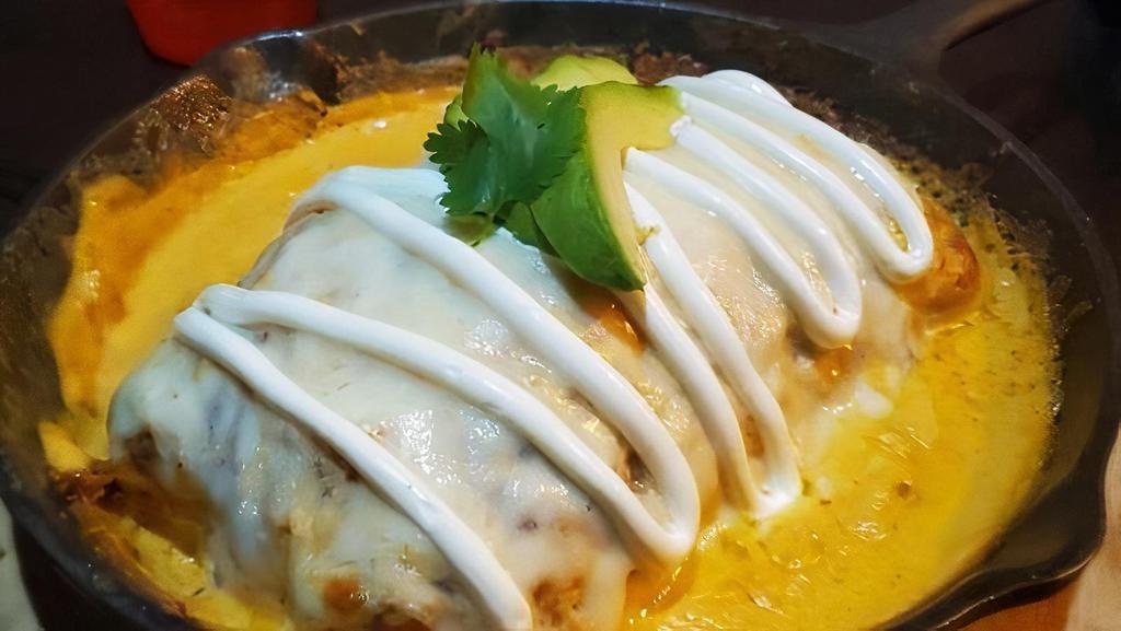 Burrito Bendito · Flour tortilla filled with Mexican rice, black beans, sour cream, and guacamole, bathed melted mozzarella cheese and served with a sauce & meat of your choice.