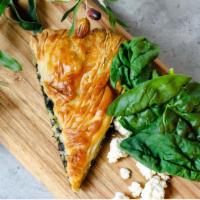 Spanakopita · Spinach sautéed in extra virgin Greek olive  oil with feta, filled into a crispy phyllo dough.