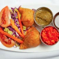 Vegetable Samosas · Crisp patties stuffed with potatoes and peas with a subtle touch of indian spices. Two pieces.
