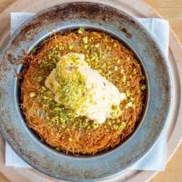 Kunefe · Shredded wheat baked with unsalted cheese and syrup and topped with pistachio and a little b...