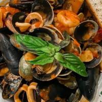 Linguini Nero Pescatore · Black squid ink linguini, sautéed calamari, shrimp, clams & mussels with shredded basil in a...