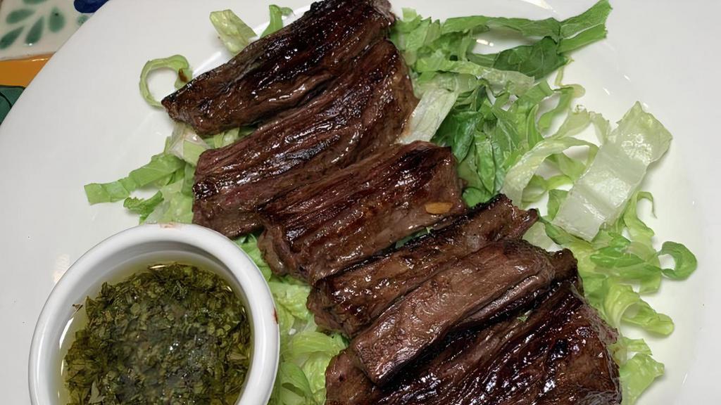 Churrasco Skirt Steak · Skirt steak grilled to perfection served with chimichurri and cebollitas.
