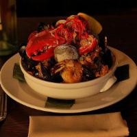 Mamajuana Seafood Paella · Half lobster, shrimp, calamari, mussels, clams, chicken saffron rice, chorizo, olives, and g...