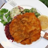 Classic Schnitzel · Breaded pork filet, fried and served with potato salad, red cabbage, and cucumber salad.