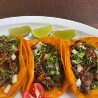 Tacos De Birria (Lamb) · Set of Three Lamb tacos served with cilantro & onions, accompanied by an 8oz lamb consume (L...