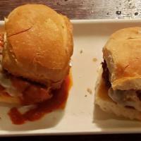 Meatball Parm Sliders · Two meatball sliders baked with tomato sauce mozzarella cheese.
