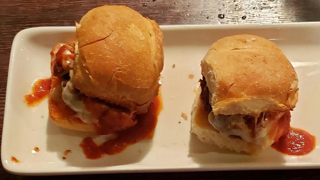 Meatball Parm Sliders · Two meatball sliders baked with tomato sauce mozzarella cheese.