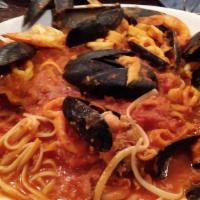 Seafood Fra Diablo · Shrimp, mussels, calamari and chopped clams in a spicy tomato sauce nested on a bed of lingu...