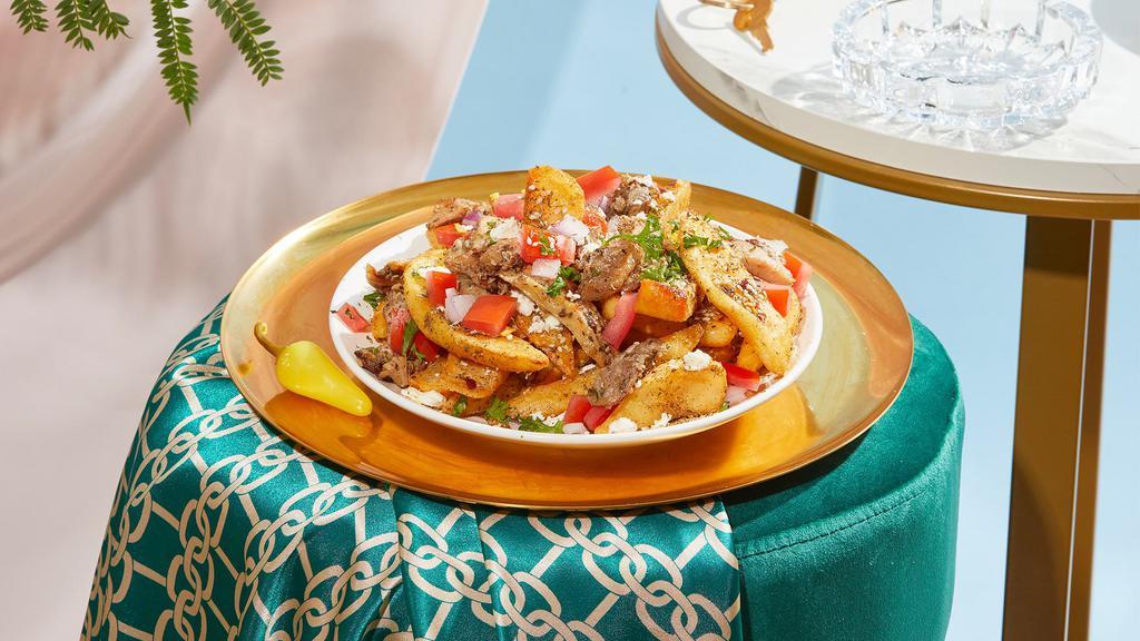 Loaded Shawarma Fries · Crispy french fries topped with your choice of shawarma, tomatoes, onions, feta, and parsley.