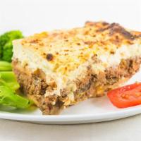 Moussaka · Layers of eggplant, roasted potatoes, and chopped meat.  Seasoned with nutmeg.  
 Topped wit...
