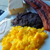 Desayuno Típico Salvadoreño · Scrambled eggs, fried beans, fried plantains, cheese, sour cream and two corn tortillas.