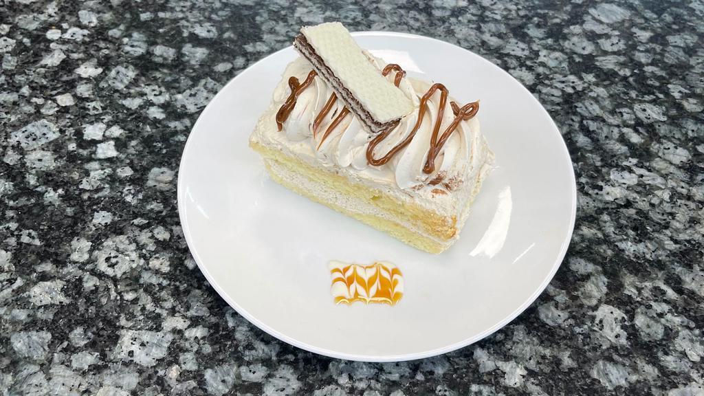 Dulce De Leche Slice · Yellow sponge with caramelize milk topped with whipped cream.