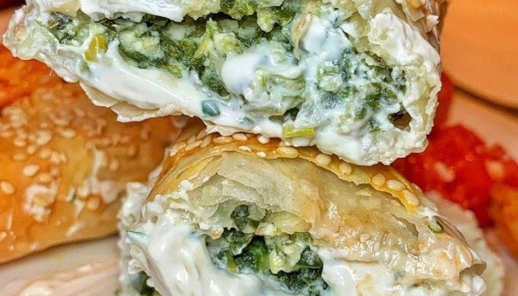 Spanakopita · Spinach and feta triangles served with herbed yogurt.