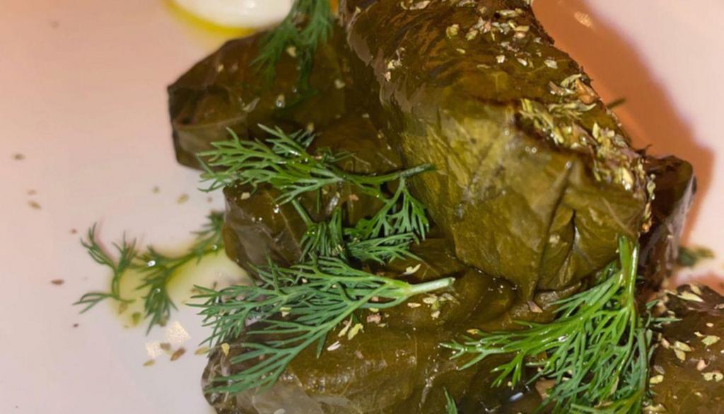 Dolmades · Hand rolled grape leaves stuffed with rice, dill and served with tzatziki.