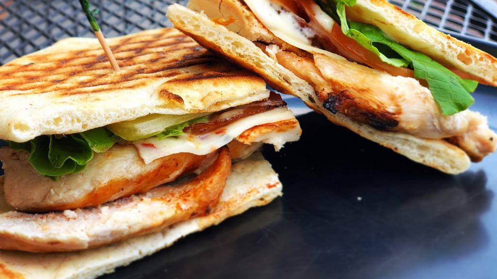 Buffalo Chicken Panini · Grilled buffalo chicken, melted pepperjack cheese, lettuce, and tomato. Served with a side of chunky bleu cheese dressing for dipping.