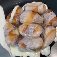 Monkey Bread · Warm bite size pieces of sweet biscuits covered in a gooey cinnamon sauce, topped with vanil...