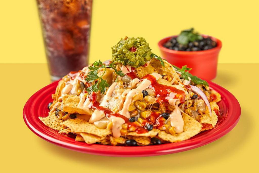 Nachos Combo · Corn tortilla chips topped with melted jack cheese, black beans, roasted corn, red onion, guacamole, red chile tomatillo & creamy red chile sauce
