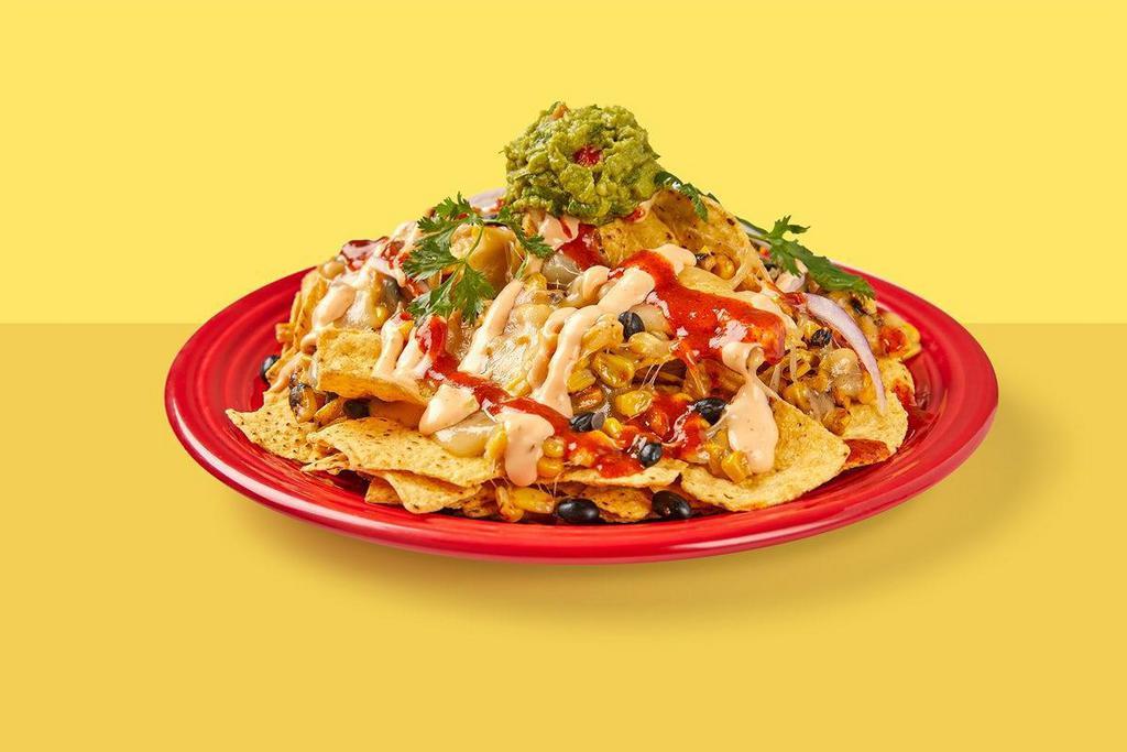 Nachos · Corn tortilla chips topped with melted jack cheese, black beans, roasted corn, red onion, guacamole, red chile sauce & chipotle mayo