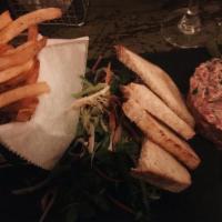 Tartare De Boeuf Au Couteau · Traditional hand-chopped steak tartare served with pommes fries and salad.