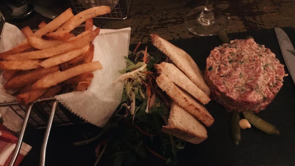 Tartare De Boeuf Au Couteau · Traditional hand-chopped steak tartare served with pommes fries and salad.