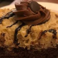 German Chocolate Cake · Two pieces layers of rich, dense chocolate devil's food cake, with two pieces layers of cust...