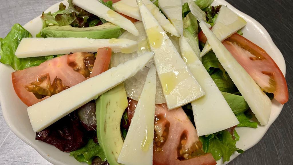 Manchego Salad · Organic spring mix, tomatoes, avocado, onions, and manchego cheese.