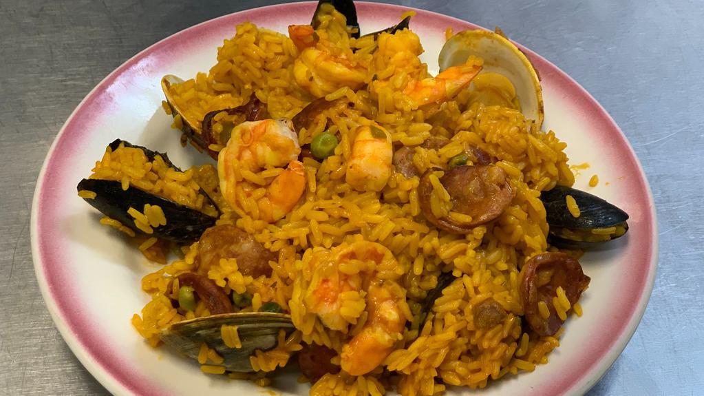 Paella Valenciana · Saffron rice, chicken, sausages, clams, mussels, and shrimps.