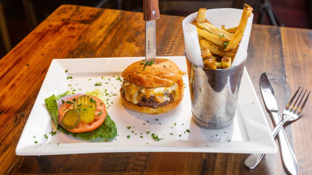 Narcisse Burger · Served with brioche bun, lettuce, tomatoes, cheddar cheese, and french fries.