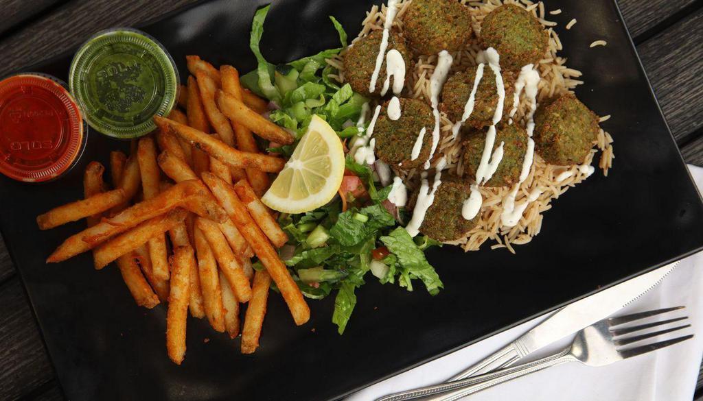 Falafel Over Rice · Served over brown basmati rice with a choice of seasoned fries and diced mixed salad or hummus and diced mixed salad.
