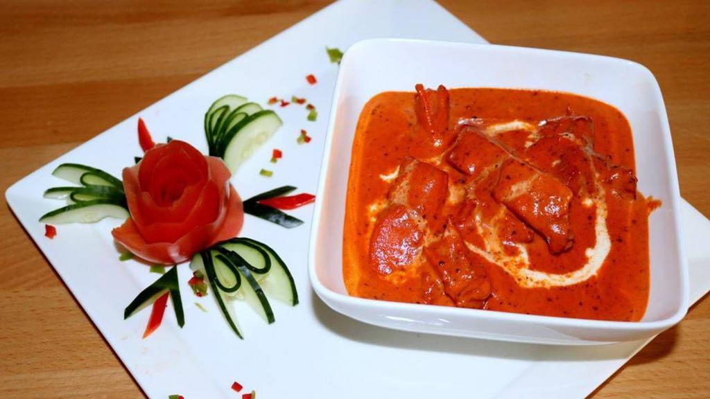 Royals Of Punjab Butter Chicken · Marinated chicken cubes are first cooked in the clay oven, then finished in a spiced creamy tomato sauce.